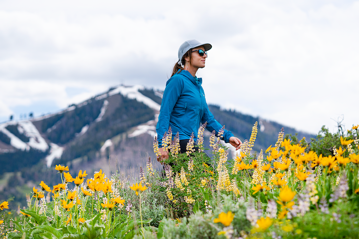 Woman crouches among mountain lupine